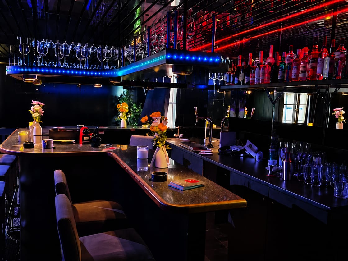 Bartresen der Kontaktbar mit Gläserhalter, Flaschenregal und farbigen Lichtleisten